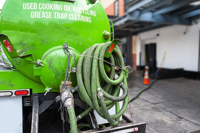 a technician pumping a grease trap in a commercial building in Bruce